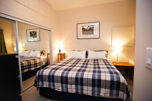 a small bedroom with a bed and a mirror at Alpenrose Revelstoke Bed & Breakfast in Revelstoke