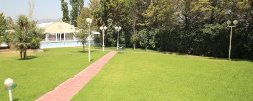 a park with a lawn and a swimming pool at Hotel Anesi in Athens