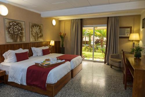 科托努的住宿－杜拉克酒店，酒店客房设有一张大床和一张书桌。