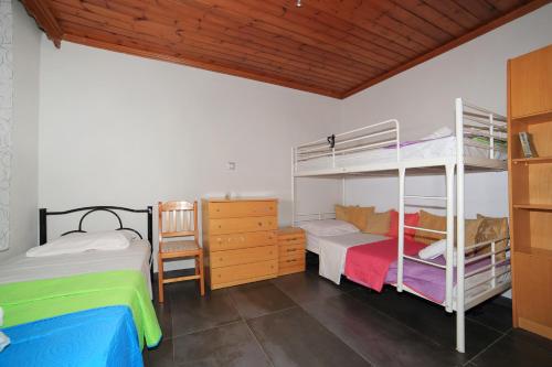 a bedroom with two bunk beds and a desk at House Loana in Neos Marmaras