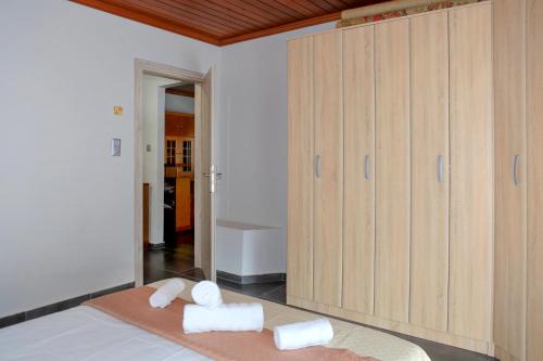 a room with towels on a bed with wooden cabinets at House Loana in Neos Marmaras