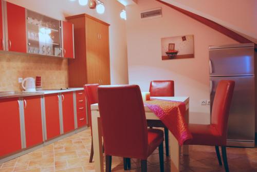 a kitchen with a table and chairs and a refrigerator at Apartments Ivetić in Kotor