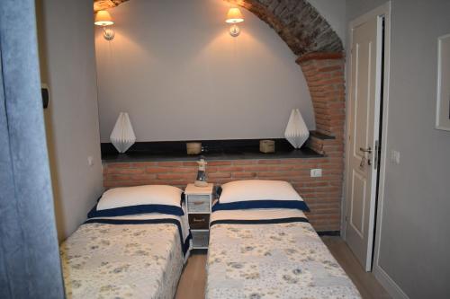 deux lits dans une chambre avec un mur de briques dans l'établissement Sea view Cornelia, à Corniglia