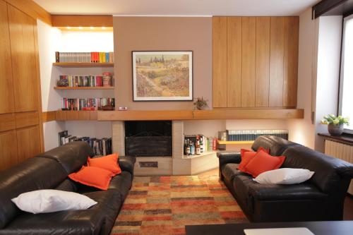 a living room with two leather couches and a fireplace at La Corte e l'Uva in Olgiate Comasco
