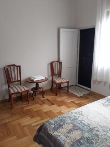 a bedroom with two chairs and a table and a bed at Merabi Guest House in Makhinjauri