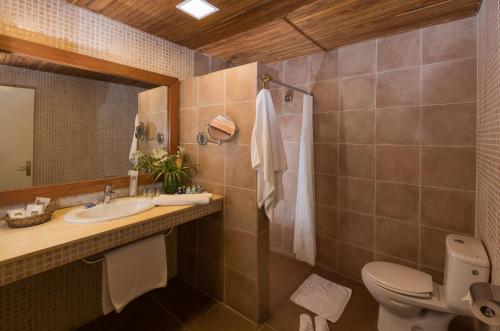 a bathroom with a sink and a toilet and a mirror at Hotel Du Lac in Cotonou