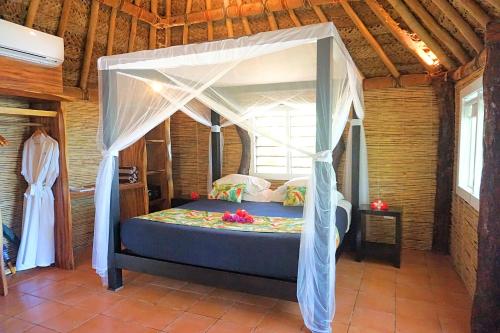 a bedroom with a bed with a canopy at Octopus Resort in Nalauwaki