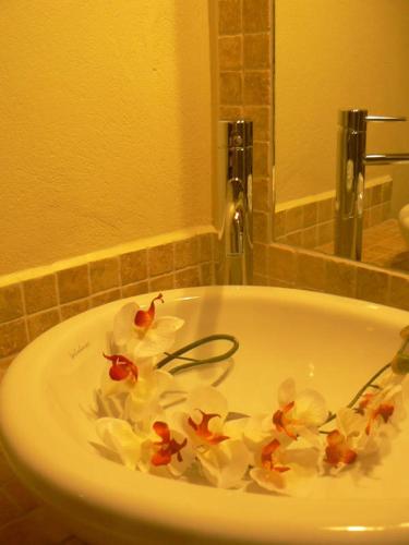 a bath tub filled with flowers in a bathroom at Donkey on the Beach in Cobbs Cross