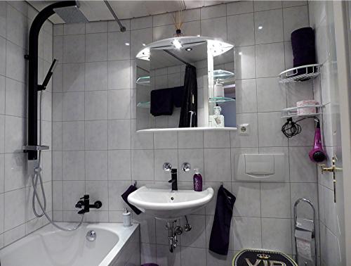 a bathroom with a sink and a mirror and a tub at Royal - Sky - Suite in Augsburg