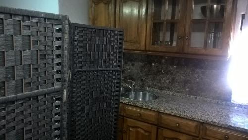 uma cozinha com um lavatório e uma bancada em Casa do Limoeiro em Quinta do Conde