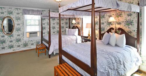 a bedroom with two beds and floral wallpaper at The Country Inn of Berkeley Springs in Berkeley Springs