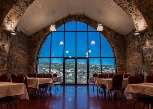 a room with tables and chairs and a large window at Domaine Saint Estève in Millau