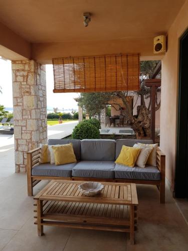 a blue couch on a patio with a coffee table at Therme Sea Luxury Lodge in Thermisia