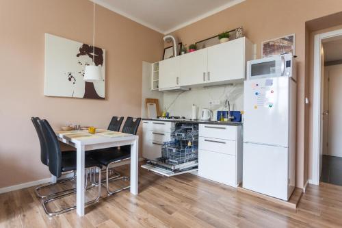Eliška في براغ: مطبخ مع طاولة وثلاجة بيضاء