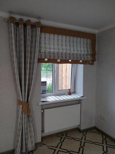 a window with a curtain in a room at Inter Hotel in Ternopilʼ