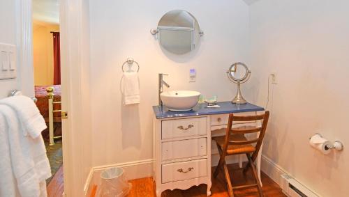 a bathroom with a sink and a mirror on a dresser at The Country Inn of Berkeley Springs in Berkeley Springs