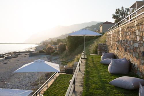a wall with pillows and an umbrella next to a beach at Mare Studios Exclusive in Plomarion