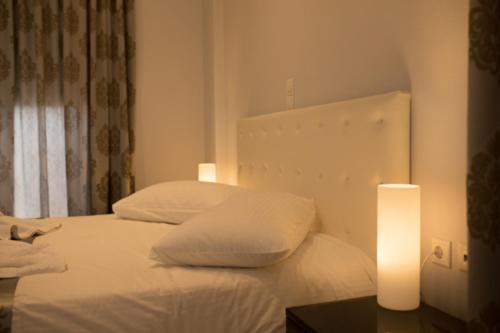 a bedroom with a white bed with two pillows at Mare Studios Exclusive in Plomarion