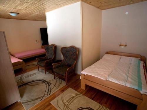 a bedroom with a bed and two chairs in it at 3M Pansioni in Vlasina Rid
