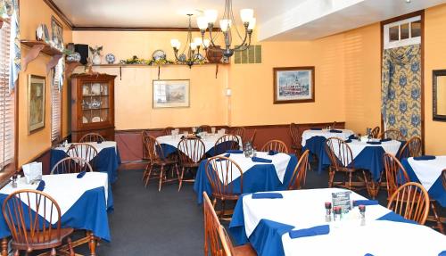 a dining room with tables and chairs with blue tablecloths at The Country Inn of Berkeley Springs in Berkeley Springs