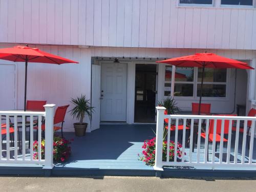 a porch with two red umbrellas and chairs at Aquastar Inn in Westerly