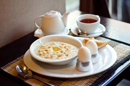 Uma tigela de cereais, ovos e uma chávena de chá. em Hotel "Otel flowerS" em Perm