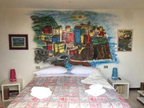 ein Schlafzimmer mit einem großen Bett und einem Gemälde an der Wand in der Unterkunft Casa Maia in La Spezia