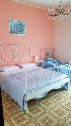 ジャルディーニ・ナクソスにあるStella Marinaのベッドルーム1室(ベッド2台、シャンデリア付)