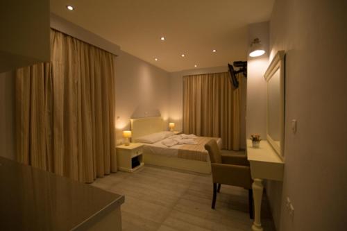 a hotel room with a bed and a desk and a sink at Mare Studios Exclusive in Plomarion
