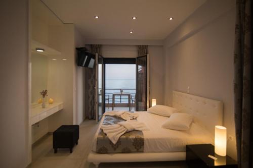 a bedroom with a bed with a view of the ocean at Mare Studios Exclusive in Plomari