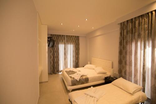 a hotel room with two beds and a window at Mare Studios Exclusive in Plomarion