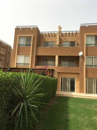 a building with a green yard in front of it at Chalet Marina Wadi Degla Families Only Pool view 2nd floor with Roof 6 adults in Ain Sokhna