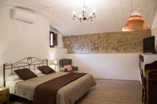 a bedroom with a bed and a chandelier at Mas Tomas in Vall-Llobrega