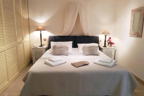 a bedroom with a white bed with two towels on it at Therme Sea Luxury Lodge in Thermisia