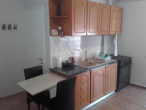 a kitchen with a table and a sink and a stove at Teris Appartment in Preveza