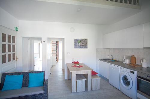 a kitchen with a table and a washing machine at Apartment Villa Bralo in Trogir