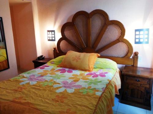 a bedroom with a bed with a large headboard at Hotel Imperial Jojutla in Jojutla de Juárez