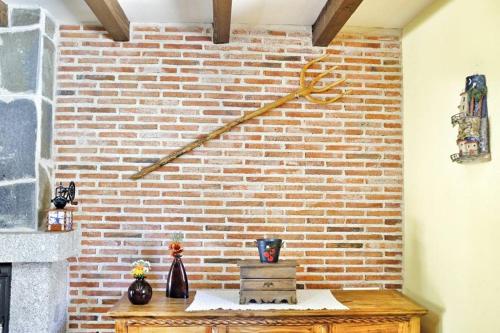 a brick wall with vases on a wooden table at Casa Rural El Corral in Ávila