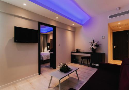 a living room with a television and a table at Frangiorgio Hotel in Larnaka