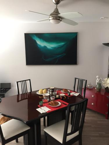 una mesa de comedor con una pintura verde en la pared en A Room at the Camelia Bed and Breakfast en Tsawwassen