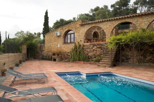 a swimming pool in front of a stone building at Mas Tomas in Vall-Llobrega