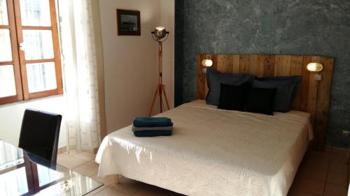 a bedroom with a bed with blue pillows on it at Appartement Belle Croix in Avignon
