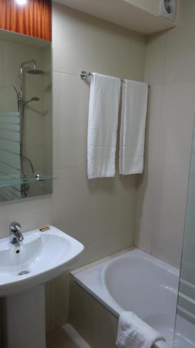 a white bathroom with a sink and a shower at Clube Pinhal da Foz in Esposende