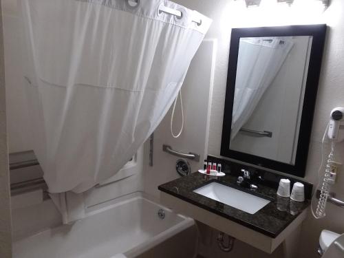 a white bathroom with a sink and a mirror at Days Inn by Wyndham Hornell NY in Hornell