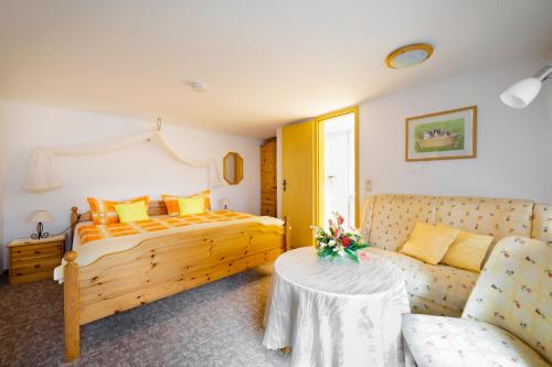 a bedroom with a bed and a couch and a table at Landpension Risch in Ilmenau