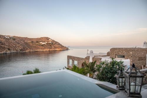 a swimming pool with a view of the water at Etesians Suites & Villas in Super Paradise Beach