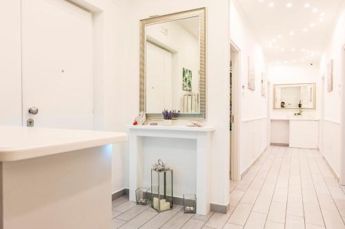 a white bathroom with a mirror and a sink at Maison De luxe in Pompei