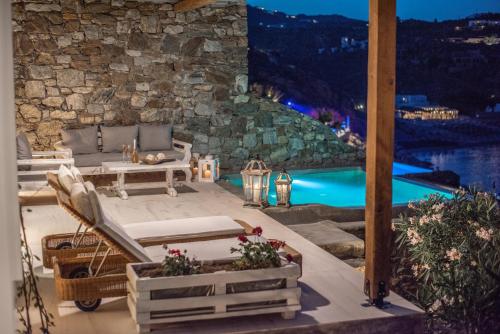 a patio with a view of a pool at night at Etesians Suites & Villas in Super Paradise Beach