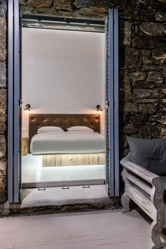 a bed in a window in a room with a bench at Etesians Suites & Villas in Super Paradise Beach