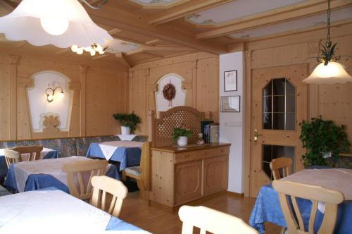 un ristorante con pareti e tavoli in legno e sedie di Tlisüra a La Villa